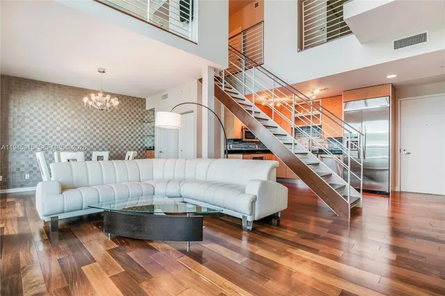 a living room with couches and a rug with wooden floor