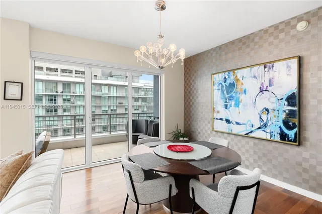 a view of a dining room with furniture a chandelier and wooden floor