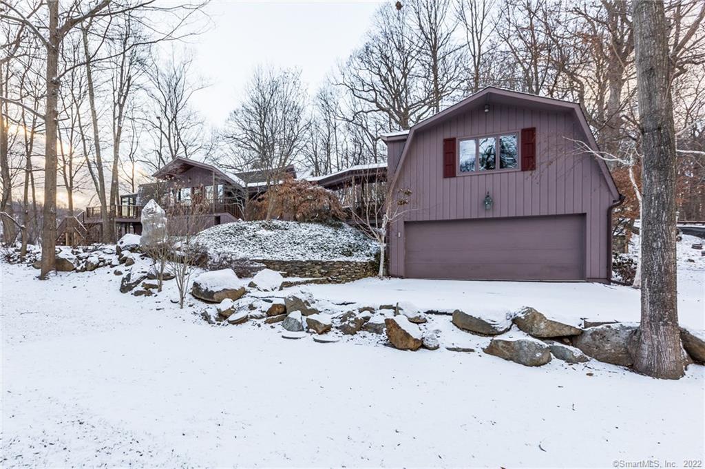 a front view of a house with a yard covered in snow