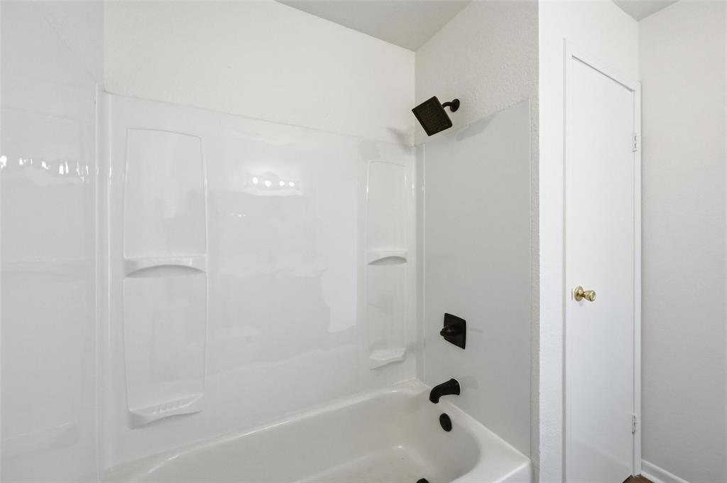 704 Graham Street Cleburne, TX 76033 - Photo 12 of 18 a bathroom with a bathtub