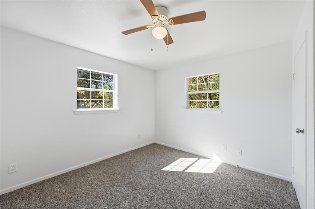 704 Graham Street Cleburne, TX 76033 - Photo 13 of 18 an empty room with windows and fan