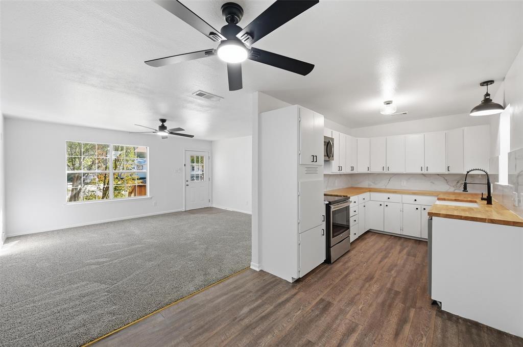 704 Graham Street Cleburne, TX 76033 - Photo 3 of 18 a kitchen with stainless steel appliances a stove a sink and a refrigerator