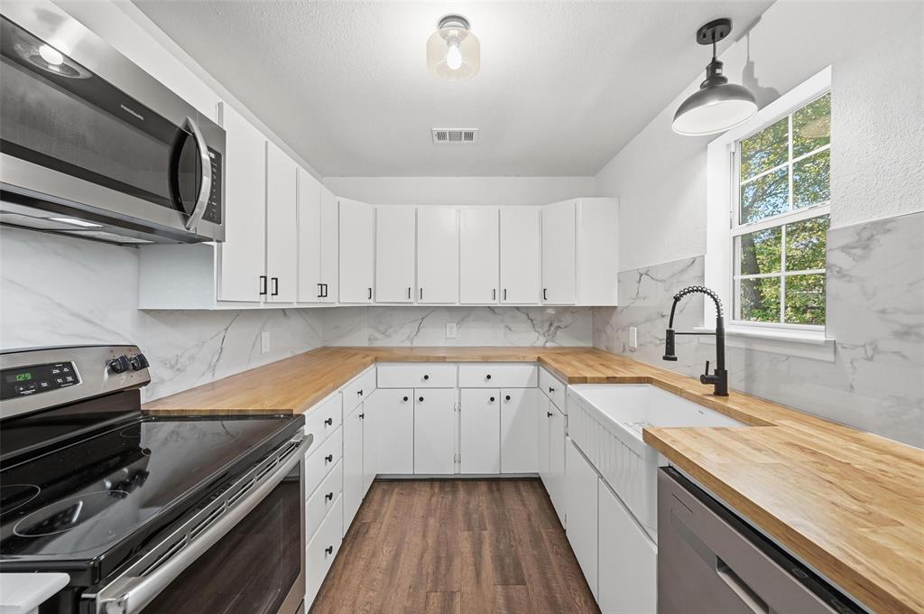 704 Graham Street Cleburne, TX 76033 - Photo 4 of 18 a kitchen with a sink stove and cabinets