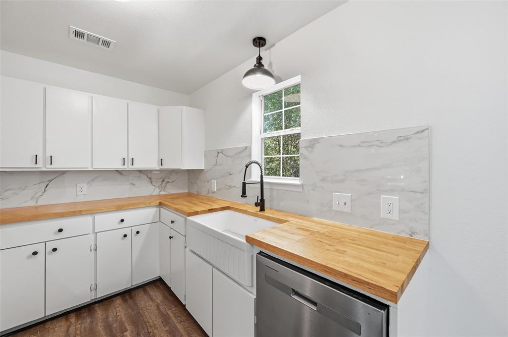 704 Graham Street Cleburne, TX 76033 - Photo 5 of 18 a kitchen with white cabinets appliances and a window