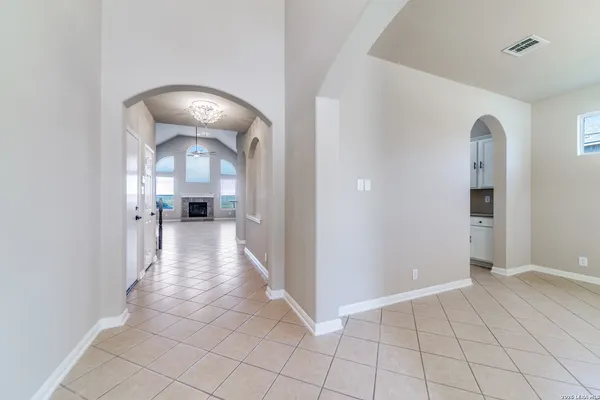 a view of a hallway with wooden floor and a living room
