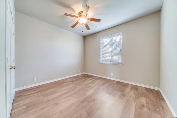 an empty room with windows and fan