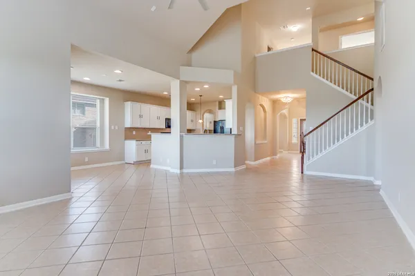 a view of a hallway with wooden floor and a kitchen