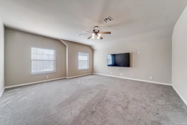 an empty room with windows and a ceiling fan