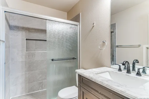 a bathroom with a granite countertop sink toilet and shower