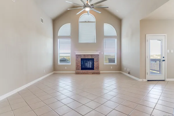 an empty room with windows and fireplace