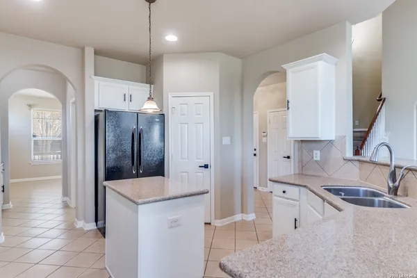 a kitchen with granite countertop a sink a stove and refrigerator