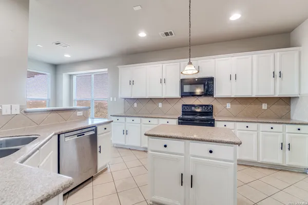a kitchen with granite countertop white cabinets and white appliances