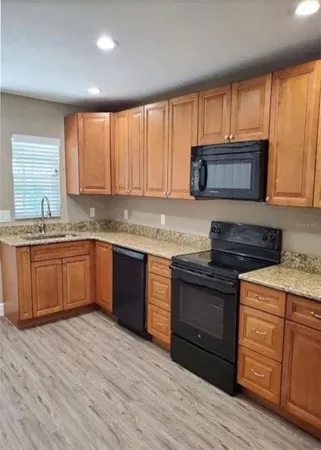 a kitchen with stainless steel appliances granite countertop wooden cabinets and a stove top oven