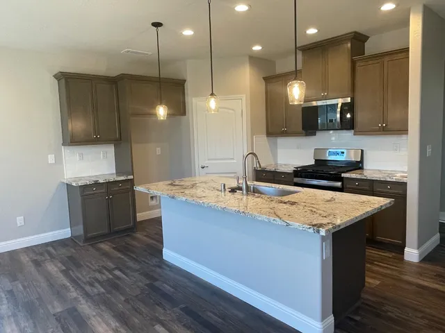 a kitchen with a sink a counter top space a stove and cabinets