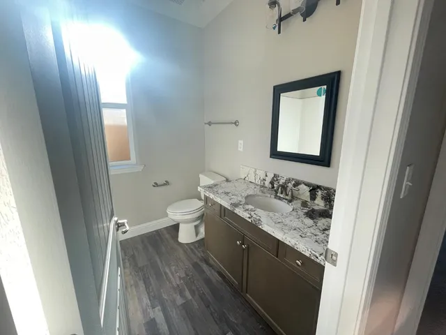 a bathroom with a granite countertop sink toilet and shower curtains