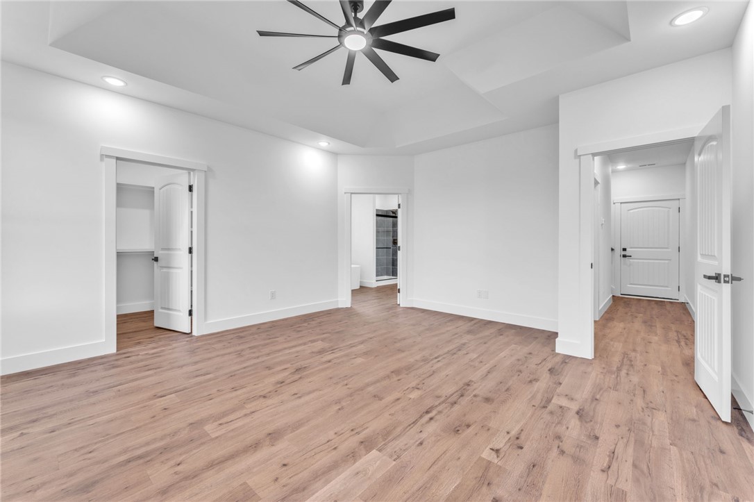 1725 Harris Bridge Road Anderson, SC 29621 - Photo 13 of 33 A generously sized primary bedroom features an elegant tray ceiling and rich wood flooring.