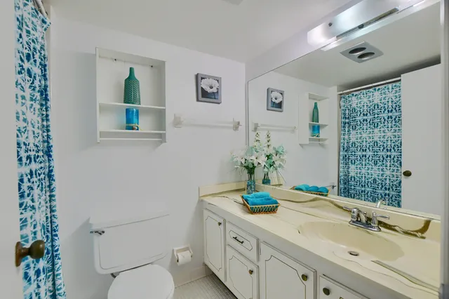 a bathroom with a granite countertop sink a toilet and shower