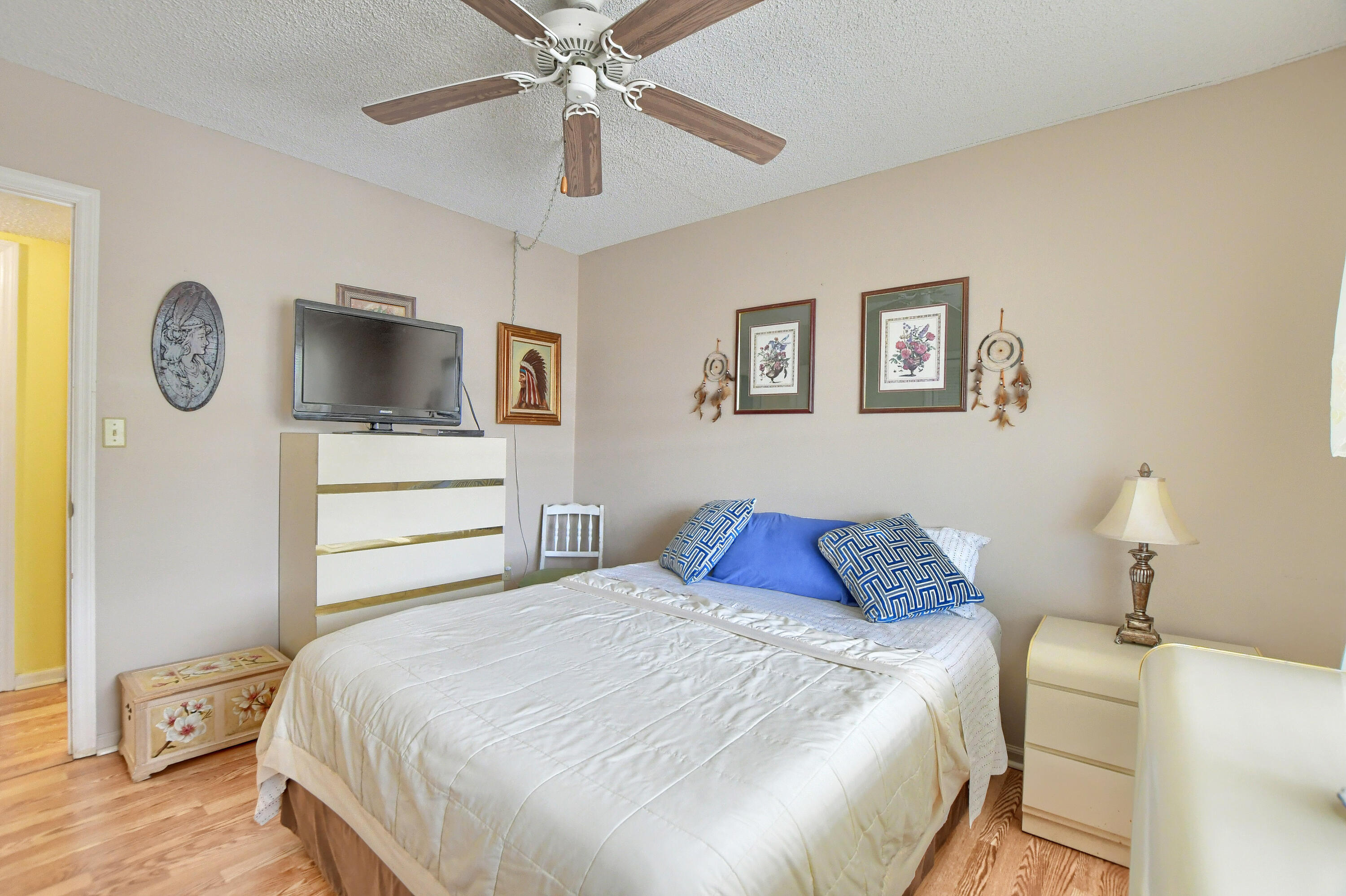 9826 Marina Boulevard, Unit 1027 Boca Raton, FL 33428 - Photo 13 of 25 a bedroom with a bed and a chandelier
