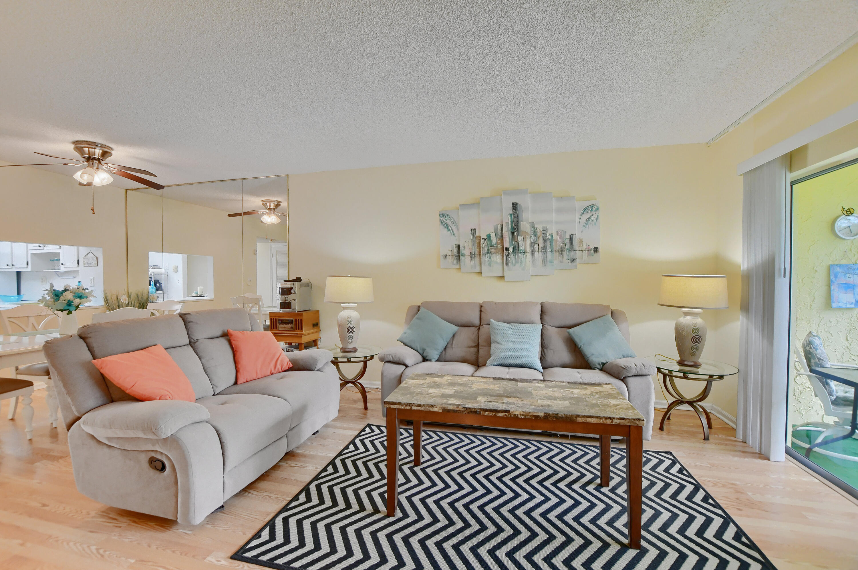 9826 Marina Boulevard, Unit 1027 Boca Raton, FL 33428 - Photo 2 of 25 a living room with furniture a rug and a chandelier