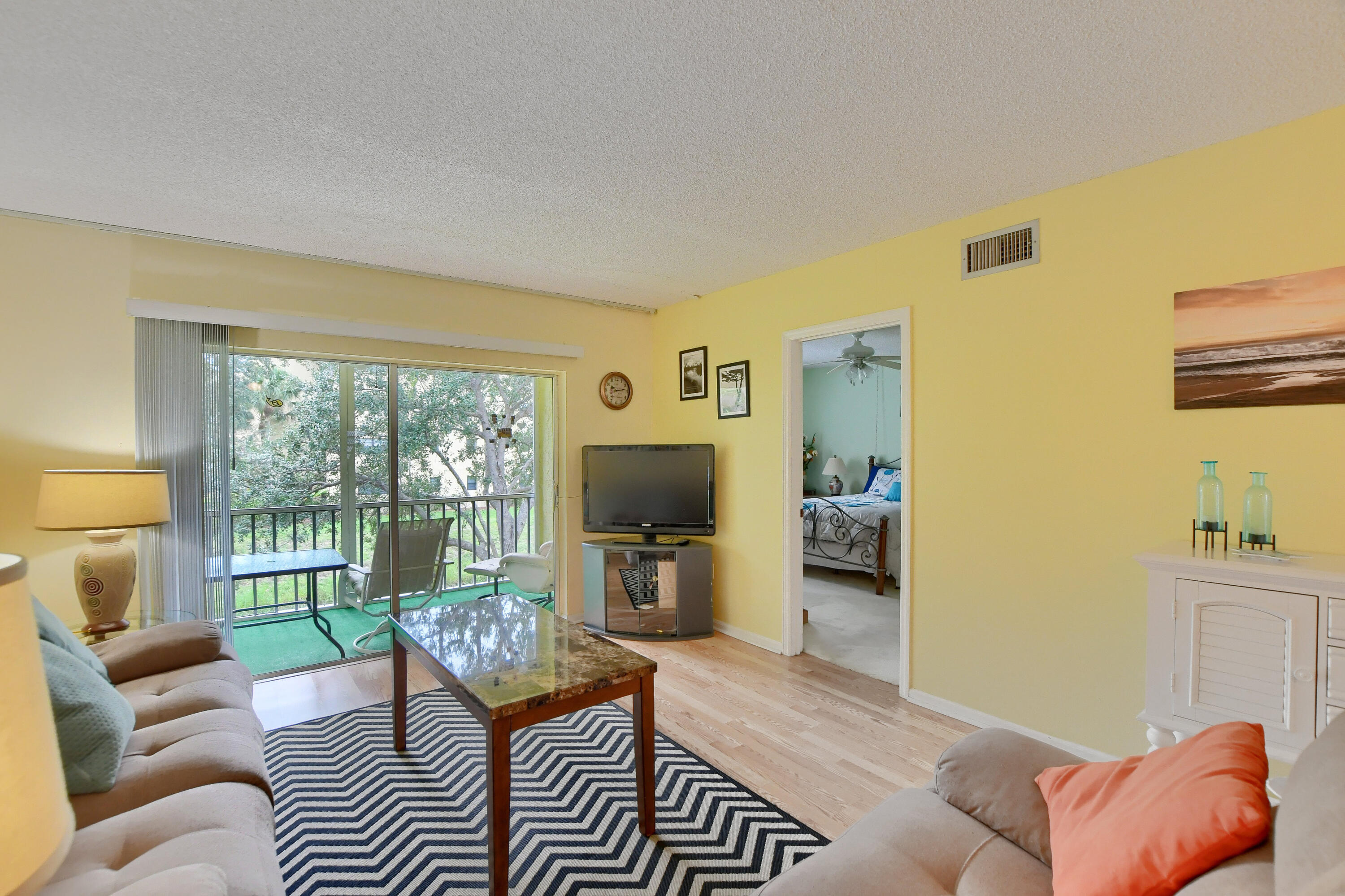 9826 Marina Boulevard, Unit 1027 Boca Raton, FL 33428 - Photo 3 of 25 a living room with furniture and a flat screen tv
