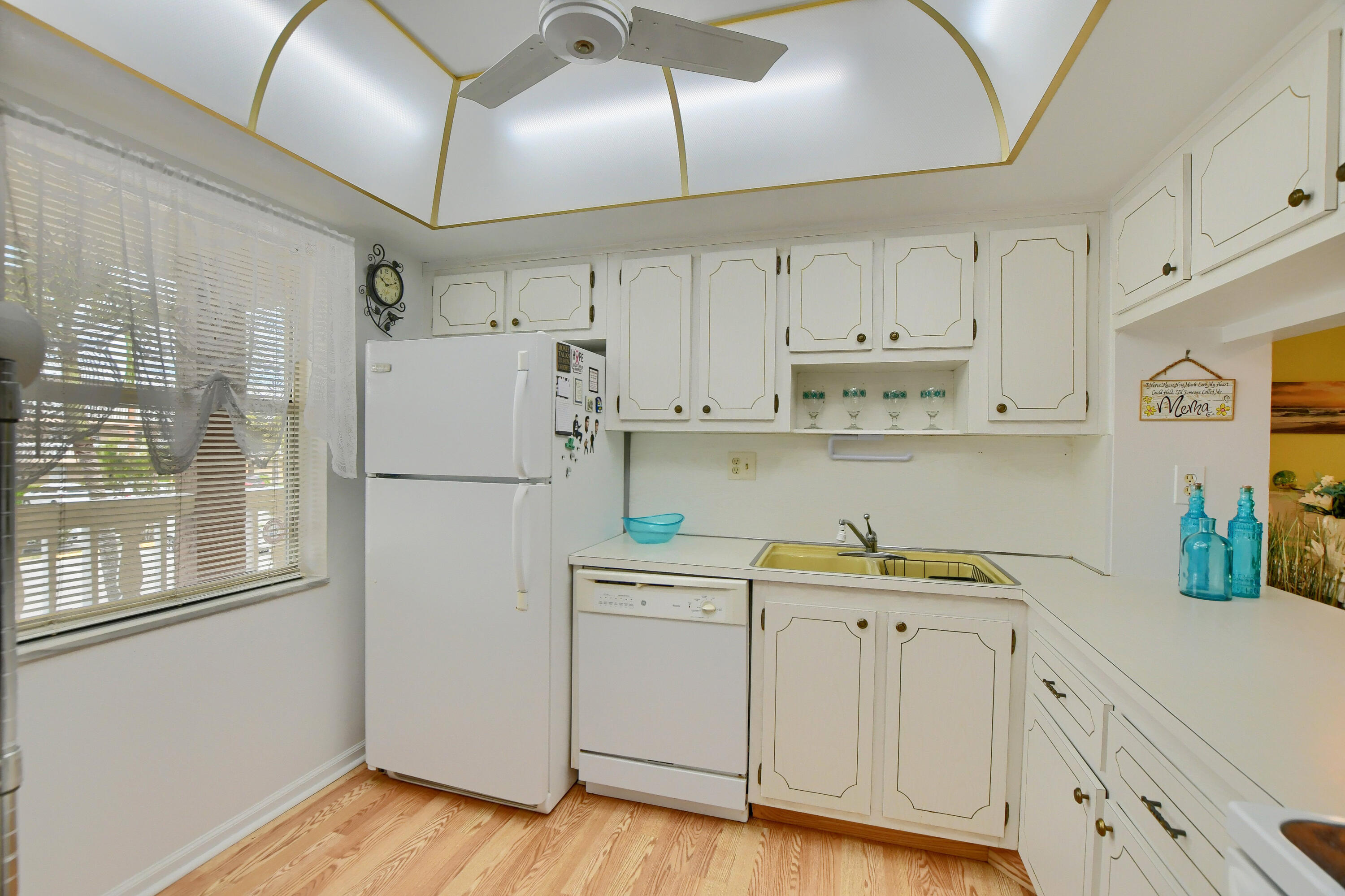 9826 Marina Boulevard, Unit 1027 Boca Raton, FL 33428 - Photo 6 of 25 a kitchen with white cabinets and wooden floor