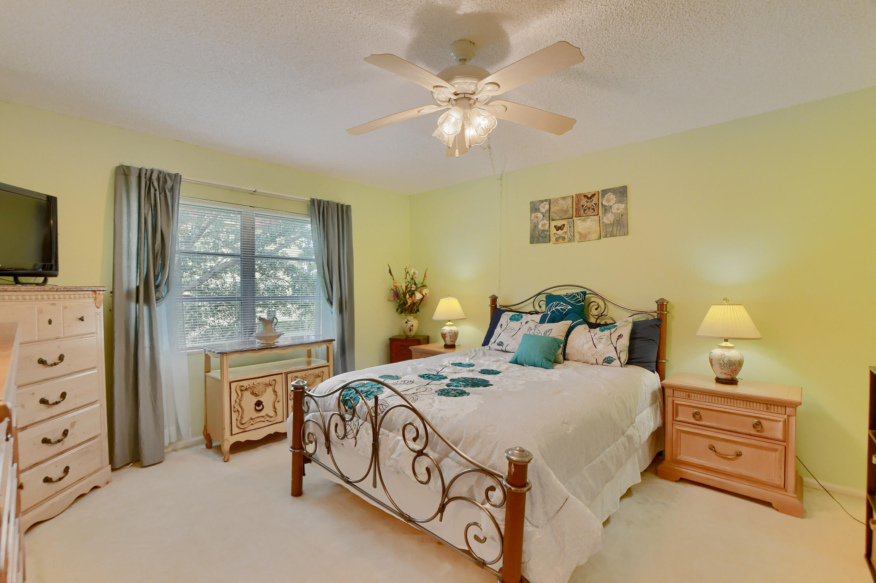 9826 Marina Boulevard, Unit 1027 Boca Raton, FL 33428 - Photo 9 of 25 a bedroom with a bed and a flat tv screen on dresser