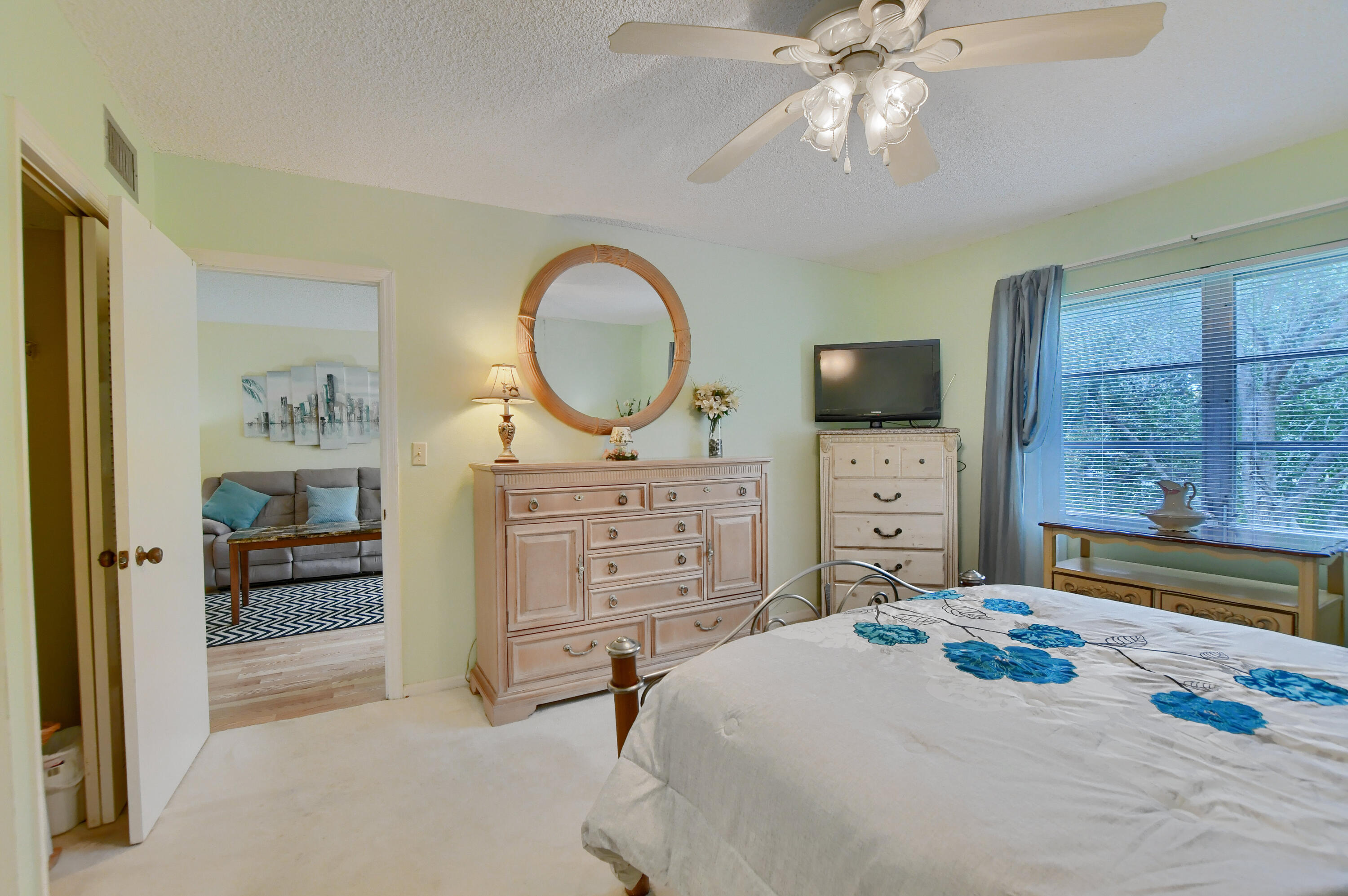 9826 Marina Boulevard, Unit 1027 Boca Raton, FL 33428 - Photo 10 of 25 a bedroom with a bed and a chandelier
