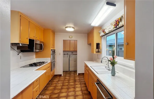 a kitchen with stainless steel appliances a stove a sink and a refrigerator