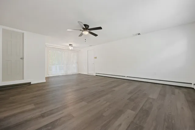 a view of an empty room and wooden floor