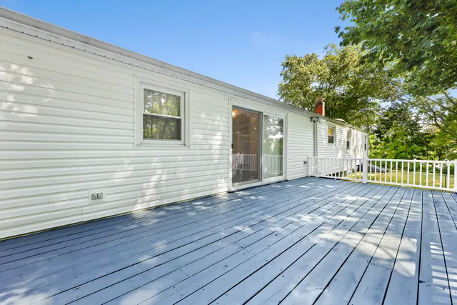 a view of a deck with wooden floor and fence and a large window