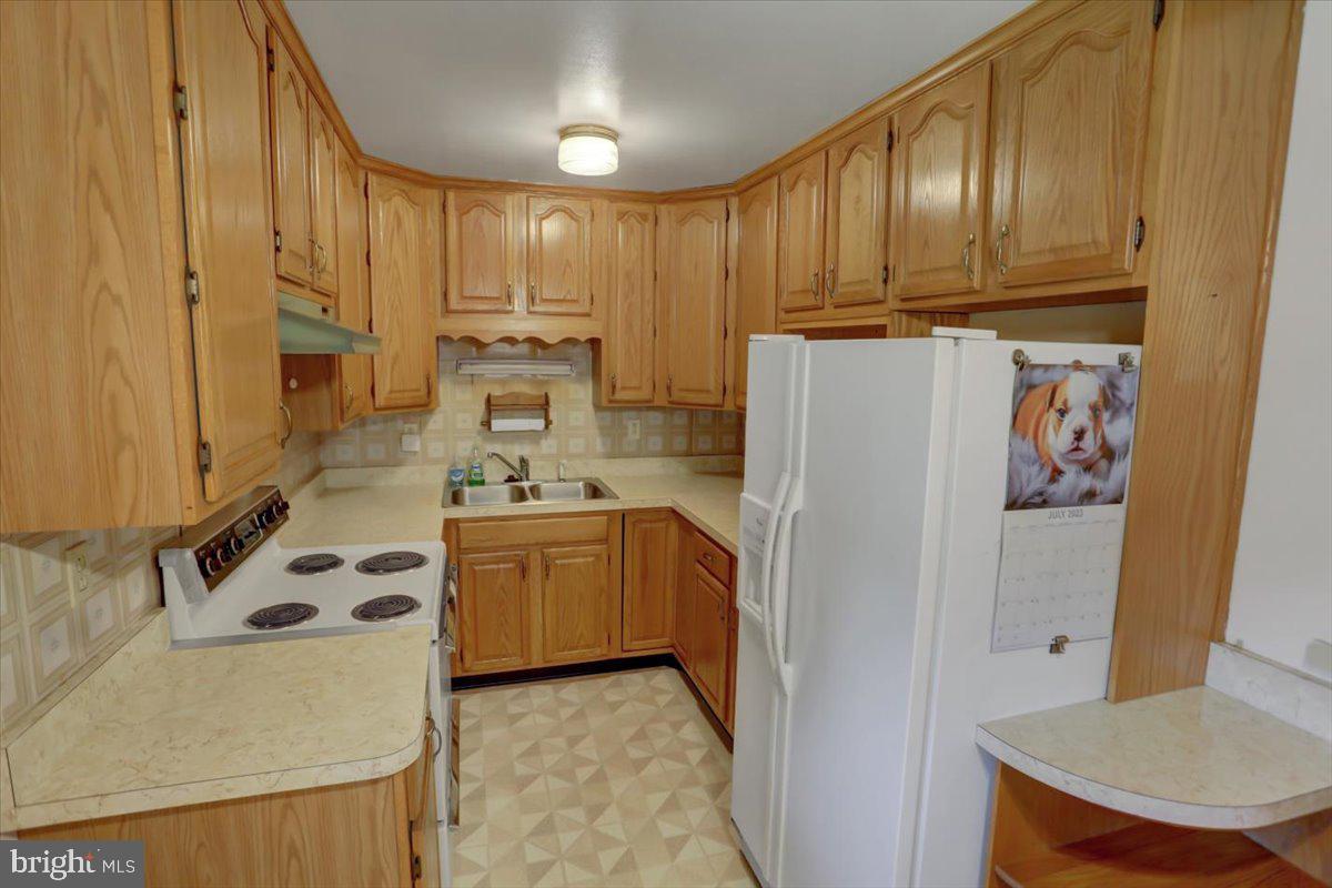 907 Cherokee Trail Frederick, MD 21701 - Photo 12 of 34 a kitchen with stainless steel appliances a refrigerator sink and cabinets
