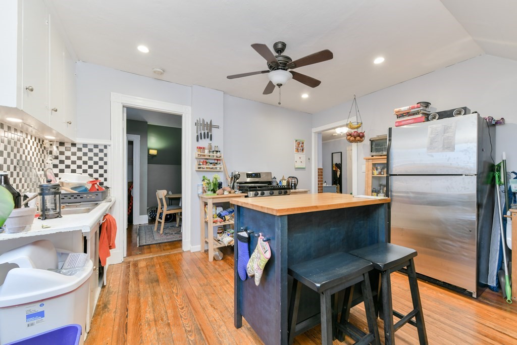 61 Montebello Road Boston, MA 02130 - Photo 32 of 35 a kitchen with stainless steel appliances a dining table chairs refrigerator and sink