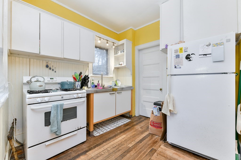 61 Montebello Road Boston, MA 02130 - Photo 9 of 35 a kitchen with a refrigerator a stove a sink and cabinets