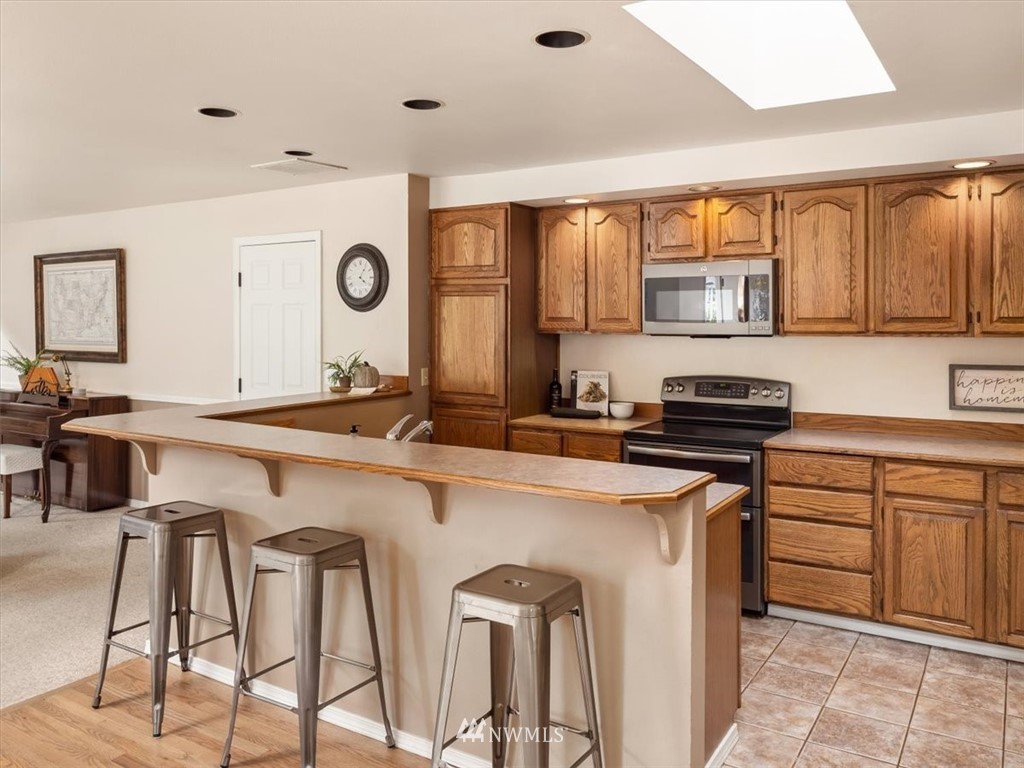 1919 243rd Place Southwest Bothell, WA 98021 - Photo 8 of 39 a kitchen with stainless steel appliances granite countertop a stove a sink and a refrigerator
