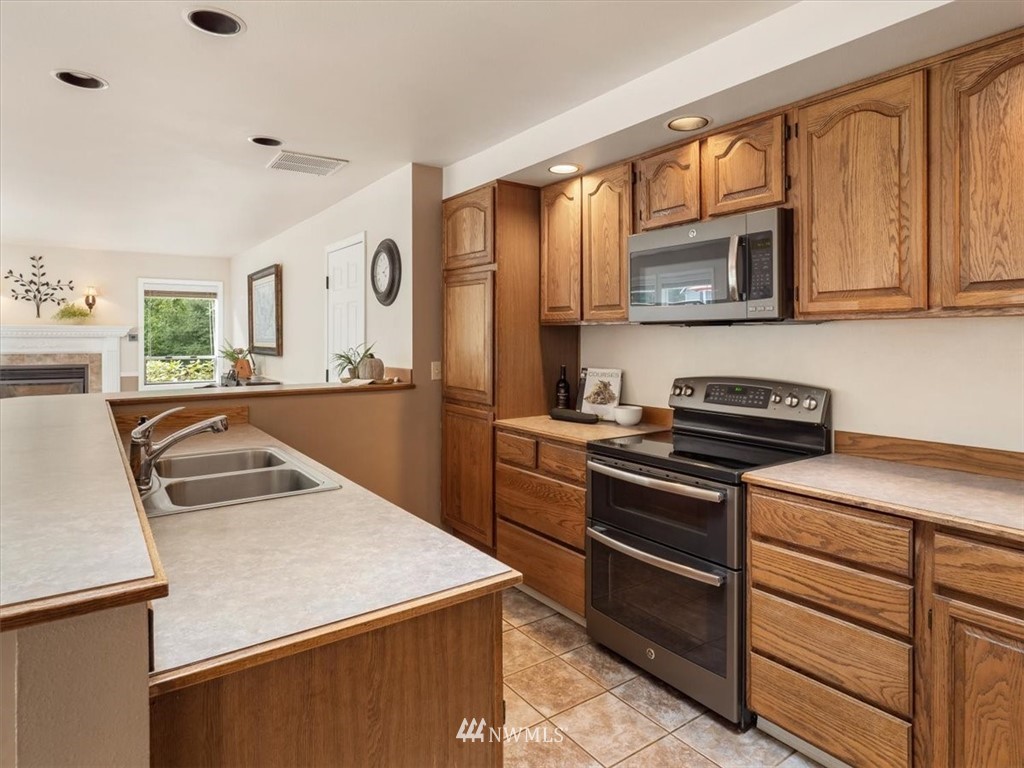 1919 243rd Place Southwest Bothell, WA 98021 - Photo 10 of 39 a kitchen with a stove a sink and a microwave