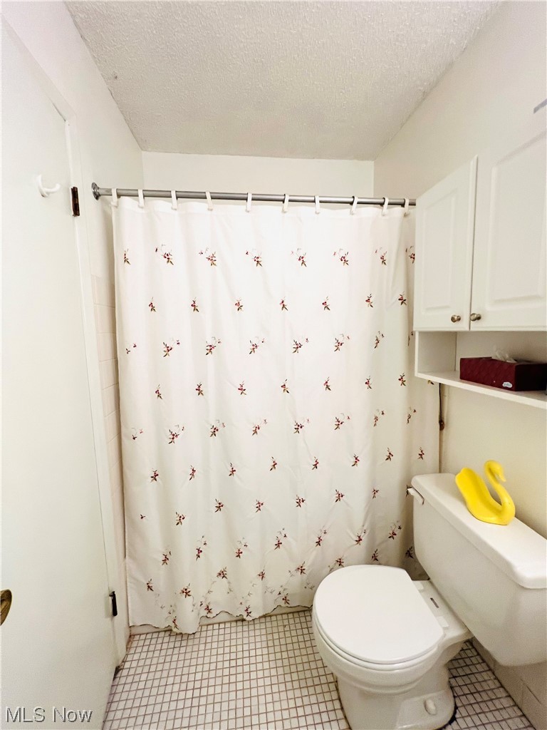 4940 Friar Road, Unit B Stow, OH 44224 - Photo 17 of 33 Bathroom featuring tile flooring, a textured ceiling, and toilet