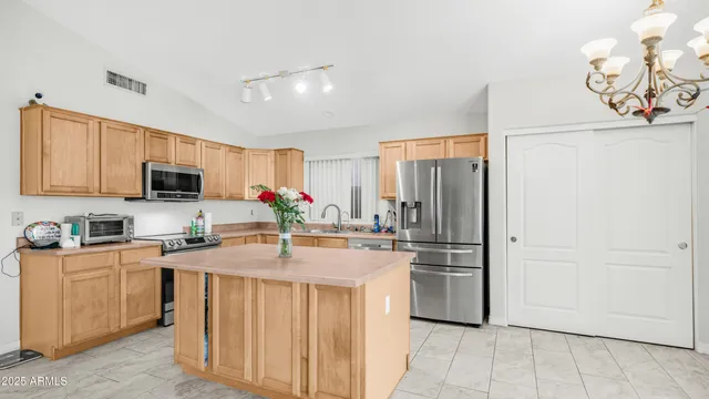 a kitchen that has a lot of white cabinets and stainless steel appliances