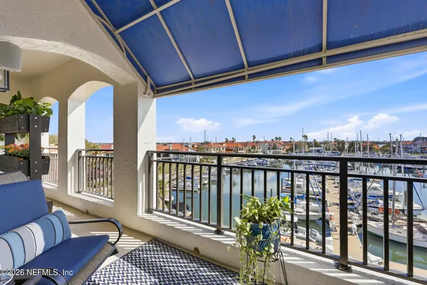 an aerial view of ocean and residential houses with outdoor space