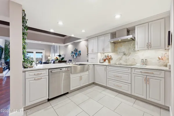 a kitchen with granite countertop a refrigerator and stainless steel appliances