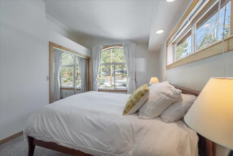 a bedroom with a bed and a large window