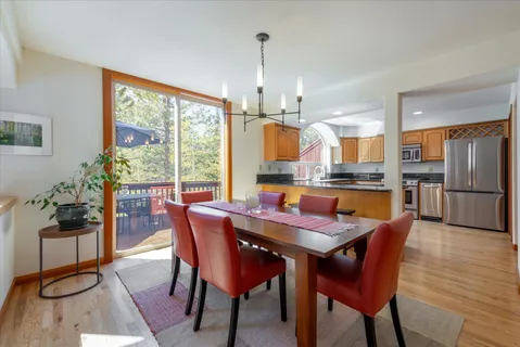 a dining room with furniture a chandelier and wooden floor