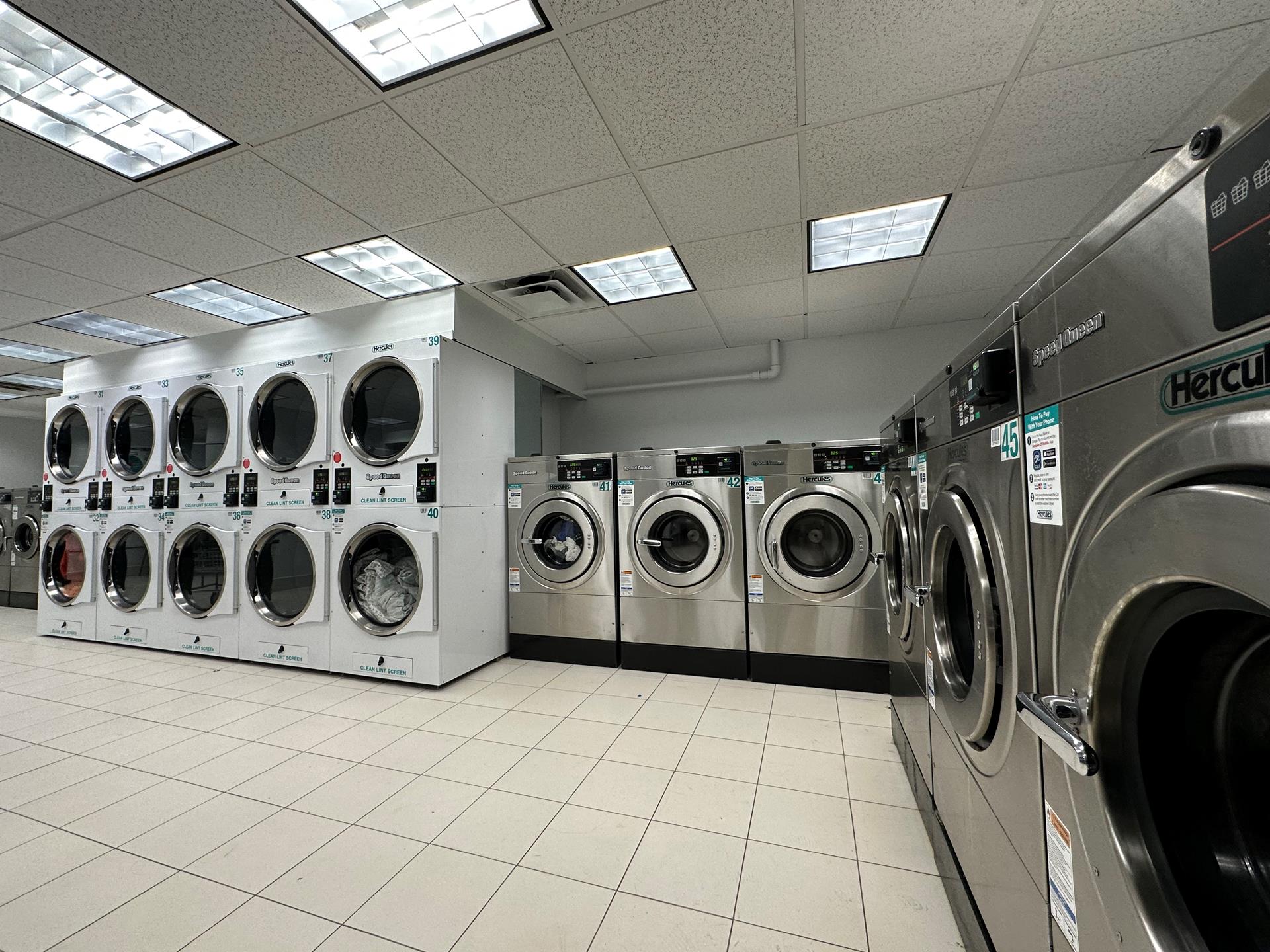 465 West 23rd Street, Unit 3C Manhattan, NY 10011 - Photo 20 of 32 a utility room with stainless steel appliances washer and dryer