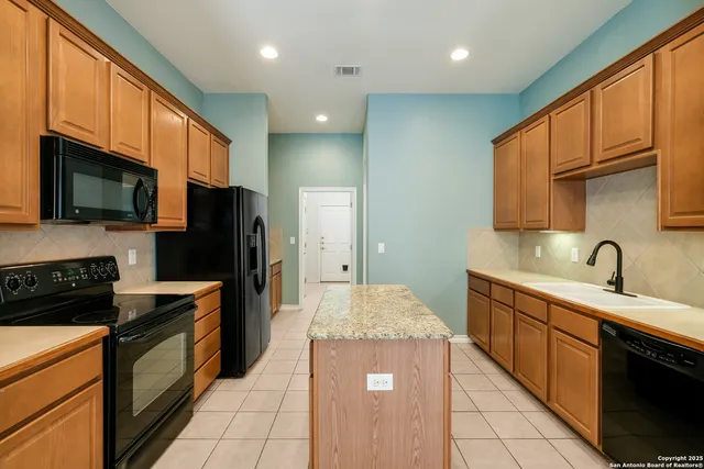 a large kitchen with stainless steel appliances granite countertop a stove refrigerator sink and cabinets