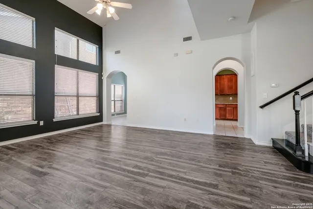 a view of an empty room with window and wooden floor