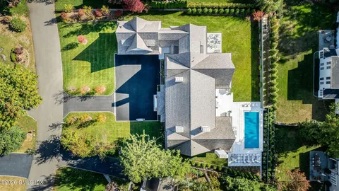 an aerial view of a house with a yard swimming pool and outdoor seating