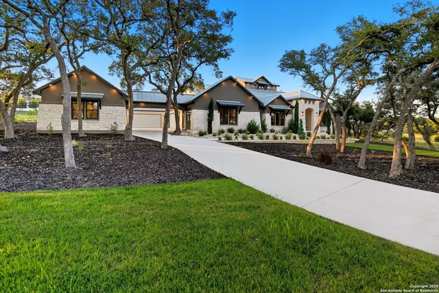 a front view of a house with a yard and trees