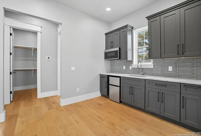 a bathroom with a granite countertop sink mirror and cabinets