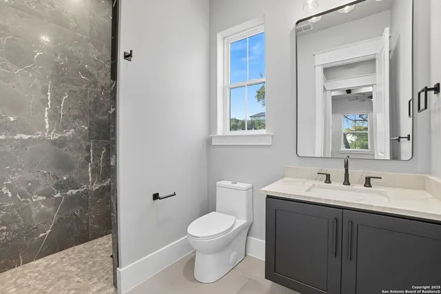 a bathroom with a toilet sink and mirror