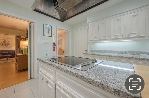 a kitchen with a granite countertop sink and cabinets