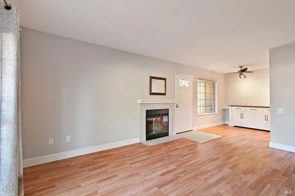 a view of an empty room with window and wooden floor